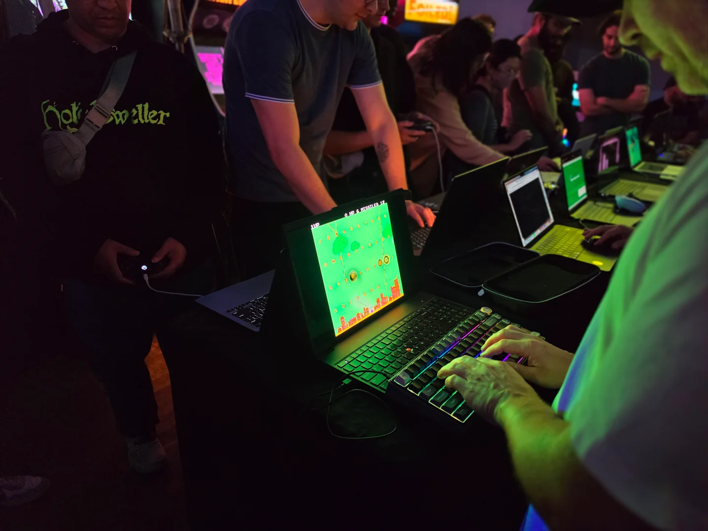 Players trying SUPER-TYPE on a laptop during playtest night.